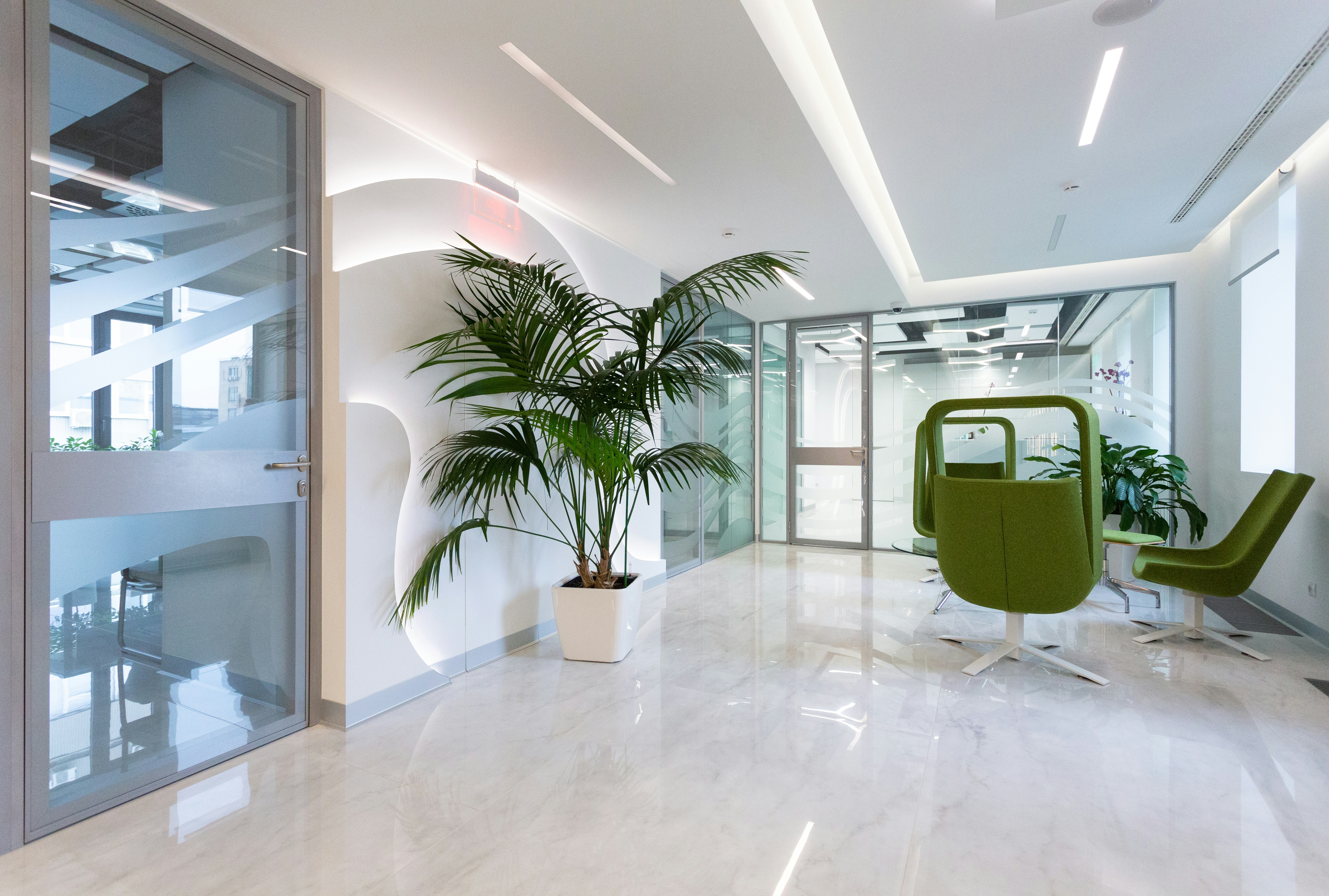 Modern medical waiting area with comfortable green chairs and natural lighting